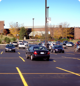 An open parking lot filled with cars on a bright sunny day.