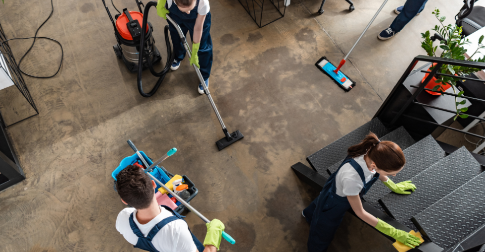 Top view of cleaners working hard in a modern office building.