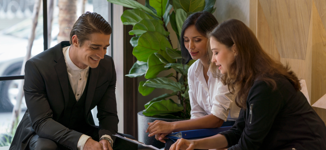 Three executive employees talking in a clean workspace.