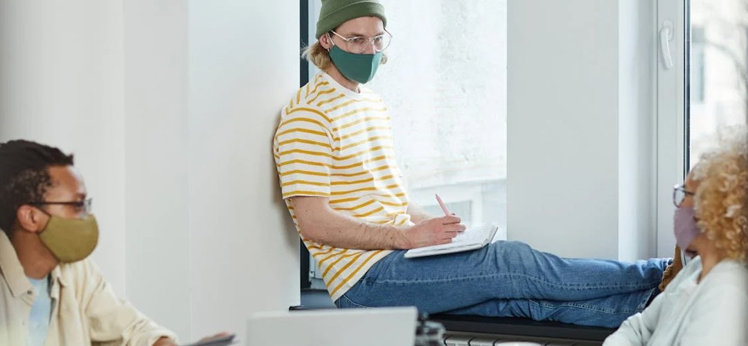 Employees wearing face masks in a meeting room.