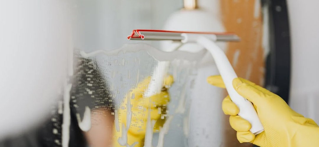 Performing a deep-clean on a mirror.