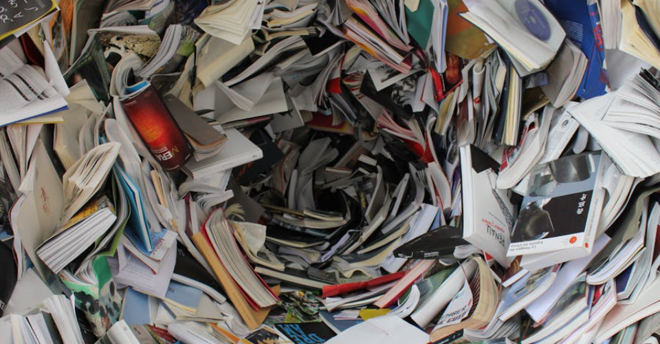 A swirling vortex of colorful books and papers. Text on some book spines is visible.