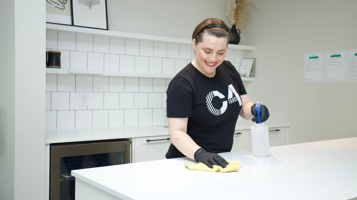 A person is thoroughly cleaning and disinfecting high-touch surfaces to reduce flu season risks.